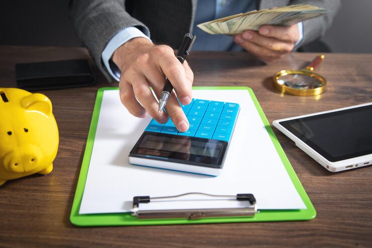 man using calculator holding dollars 220873 11868